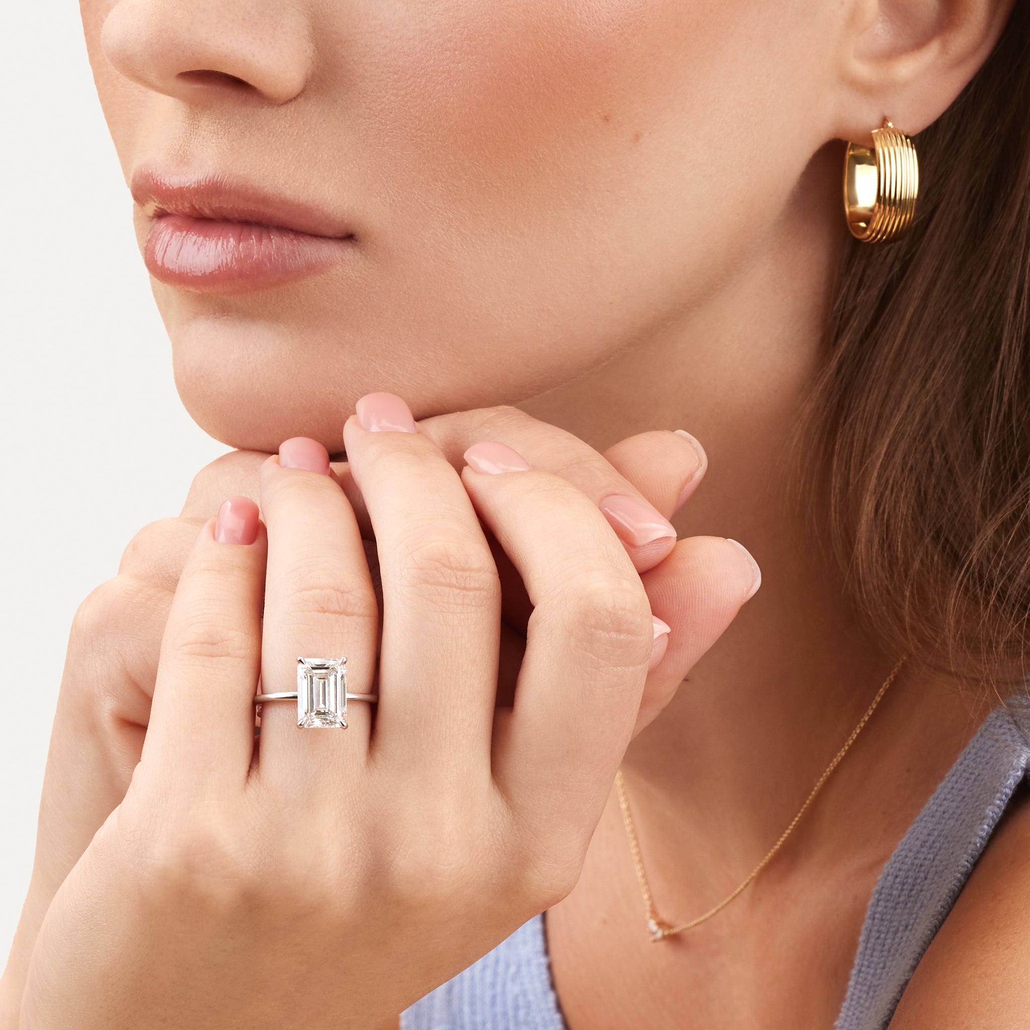 Emerald lab diamond engagement ring on model.